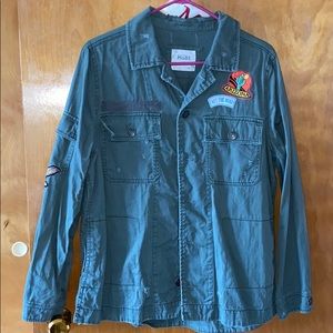 Green jacket w/ different emblems sawn on